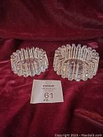 Pair of vintage clear crystal gear design bowls sitting on burgundy fabric background