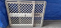 Front view of plastic expanding baby gate showing mesh pattern and locking mechanism.