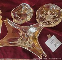 Three thick glass bowls displayed together on red fabric.