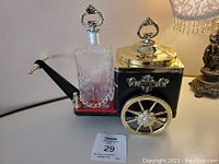 Musical decanter carriage holding the glass decanter and visible wheel design with the ice bucket and lid on top