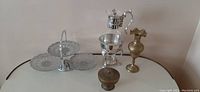 Photo showing all four items: three-tiered server, carafe with warmer, brass vase, and small lidded brass bowl based on seller description.