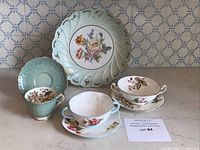 Full view of Limoges stemmed platter, Aynsley cup and saucer, Adderley and Shelley soup bowls with saucers grouped for lot overview.