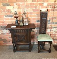 Full view of cabinet and chair against brick wall