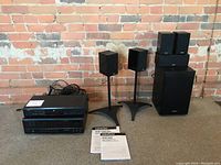 Full lot showing receiver, DVD player, manuals, speaker system components and stands