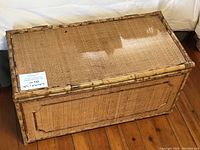 Front view of closed trunk chest showing woven cane panels and bamboo frame