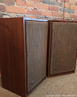 Side view showing the wood grain finish and cloth speaker covers with small JVC logo on bottom right corner.