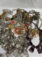 Top view of 10 vintage chunky necklaces laid out showing various chain styles and bead decorations in gold, silver, black tones
