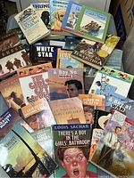 Photo showing a variety of children's novels with colorful covers and titles visible including 'The Girls Get Even' and 'There's a Boy in the Girls' Bathroom'