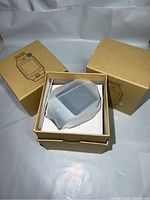 Three brown cardboard boxes for smart watches, one box partially open showing watch inside wrapped in white protective sleeve.