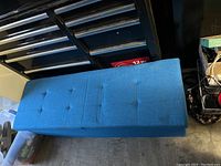 Blue cloth bench top view showing button tufting and smooth fabric.