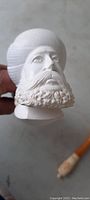 Close-up photo of the large carved face on the bowl of the pipe