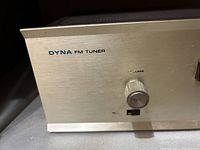 Close-up of one Dyna FM tuner front panel showing volume knob, switch and rubbed text.