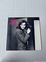 Front of vintage Eddie Money vinyl record cover with black and white photo of Eddie Money in striped suit, pink signature text.