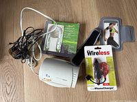 Top view of all items including cables, Royal shredder, phone armband, wireless phone charger in packaging and a small white device.