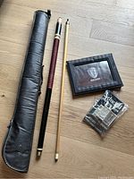 Overview photo showing the pool cue, black carrying case, Warner Bros picture frame, and Schick razor with blades in sealed original packaging.