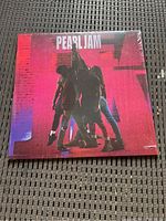Front cover of the Pearl Jam Ten vinyl LP record showing band members in silhouette against red and black background with 'Pearl Jam' text on top.