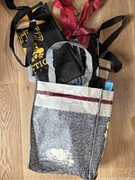 Overview of multiple Roots Canada reusable shopping bags showing various colors, sizes, and folded handles