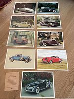 Nine classic and vintage car collector prints laid out on floor showing a variety of classic cars from the Imperial Esso dealer with differing colors and models.