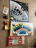 Full view of board games and accessories included in the lot on a floor surface, showing Star Wars game board, Dirty Water game box, Yard Sale game box, and assorted small items like dice and game pieces.