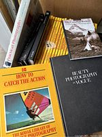 Photo showing a collection of vintage photography books including the Kodak Library of Photography series with distinctive yellow covers, Practical Photography, Beauty Photography in Vogue, and The Canadian Rockies history in photographs.