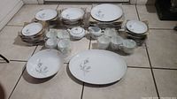 Full set of American Enterprises fine china pieces laid out on floor showing all items included in the 53 piece lot