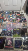 Photo showing a variety of Batman hard cover comics including The Cult and Batman 3D editions, arranged on the floor.