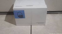 Image of the original unopened and sealed retail box for Plantronics Savi 720 headset, white box with blue label showing headset model.