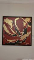 Full front view of the framed abstract floral painting featuring red, black, and gold colors.