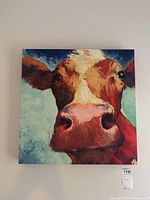 Front view of colorful canvas depicting a cow's face in close-up with expressive brush strokes.