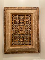 Front view of the framed wooden carved wall art panel showing the entire piece with intricate open lattice design and decorated motifs