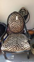 Front view of large zebra patterned upholstered chair showing full chair with rounded back and armrests.