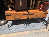 Two wooden end tables with metal bases displayed outdoors showing front view including drawer handles and metal corner brackets.