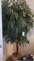 Front view of faux tree with foliage and ceramic planter