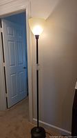 Full view of the floor lamp showing the plastic shade illuminated, standing at about 71 inches tall.