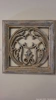 Front view of the square molded wall art panel showing ornate circular relief design and distressed frame.