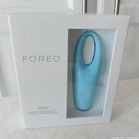 Front view of sealed Foreo Iris eye massager box showing mint blue device through window.
