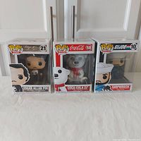 Front view of three boxed Funko Pop figures: Edgar Allan Poe #21, Coca-Cola Polar Bear #58, Shipwreck #10.