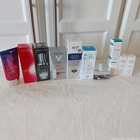 Full lot of nine skincare products arranged in a line showing packaging and bottles/tubes.