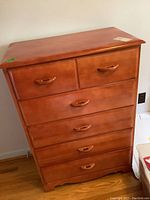 Front view of the five-drawer maple dresser showing shape, color, and handle design