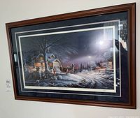 Framed, matted Terry Redlin limited edition print titled 'Winter Wonderland' of a snowy winter village scene showing houses, horse-drawn sleigh, and people.