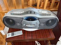Photo of the front side of Sony portable stereo showing speakers, central panel, and remote on the table
