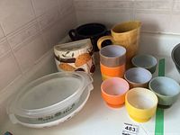 Overview of glass bakeware, dessert dishes, ceramic mushroom kitchen holder, and pitcher on kitchen counter