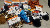 Broad view of multiple pet costumes laid out showing variety of colors and animal patterns.