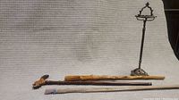 Overall view showing antique metal ashtray stand and three wooden walking canes with various carved designs and materials