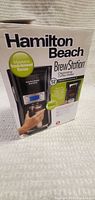Box photo front of Hamilton Beach BrewStation coffee maker showing branding and product image.
