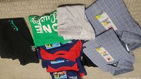Top view of mixed lot including blue plaid IZOD dress shirts, assorted t-shirts, and gray underwear