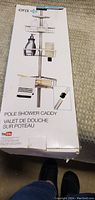 Box showing Era brand pole shower caddy with image and product details