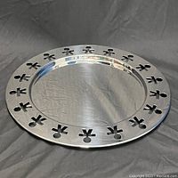 Full view of the large round metal tray showing cut-out child figure design around the rim