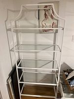Assembled bookcase showing overall white metal frame with curved indent design and five glass shelves