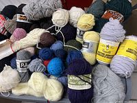 Overview photo showing large variety of yarn skeins in multiple colors and brands.